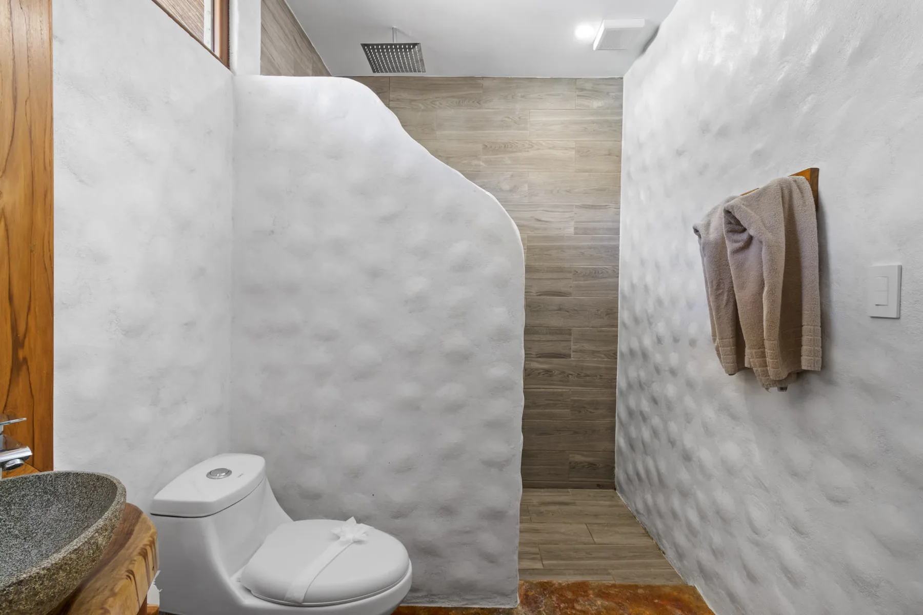 Un baño con inodoro, lavabo y zona de ducha.