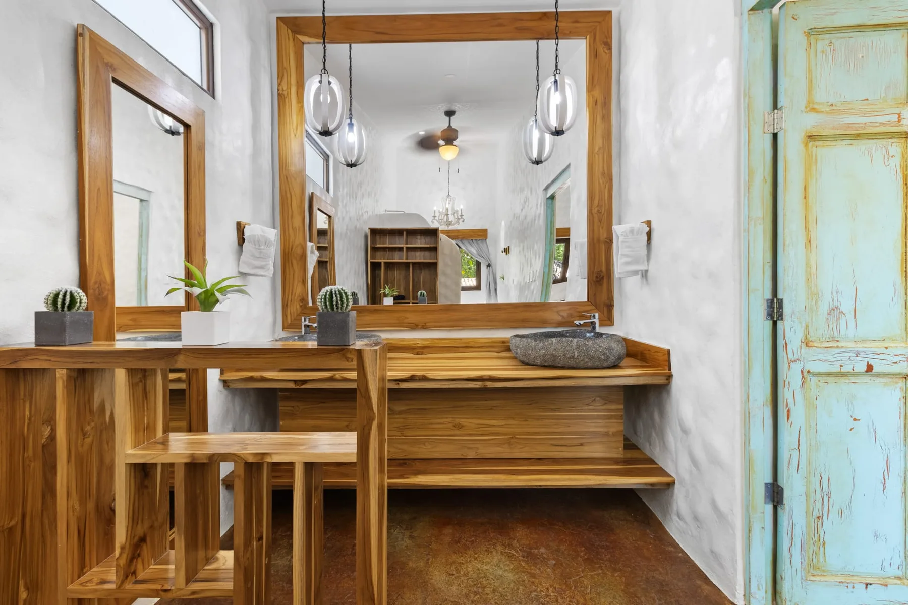 Un tocador de baño de madera con un espejo grande y lavabo.