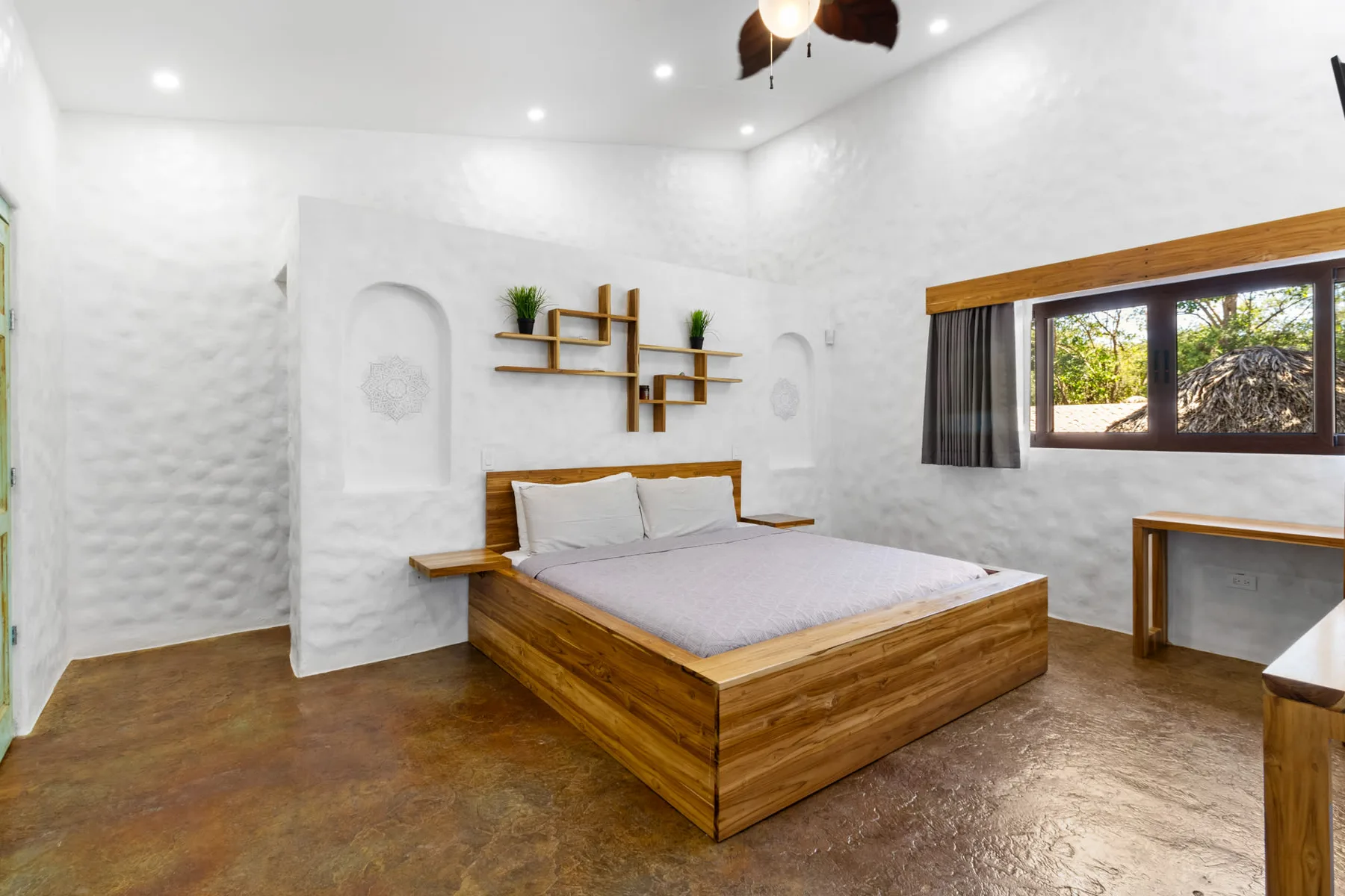 Un dormitorio luminoso con una cama de madera y una ventana grande.