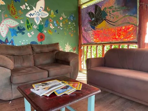 Zona común: Una sala colorida con dos zonas para sentarse, una mesa baja y paredes pintadas.