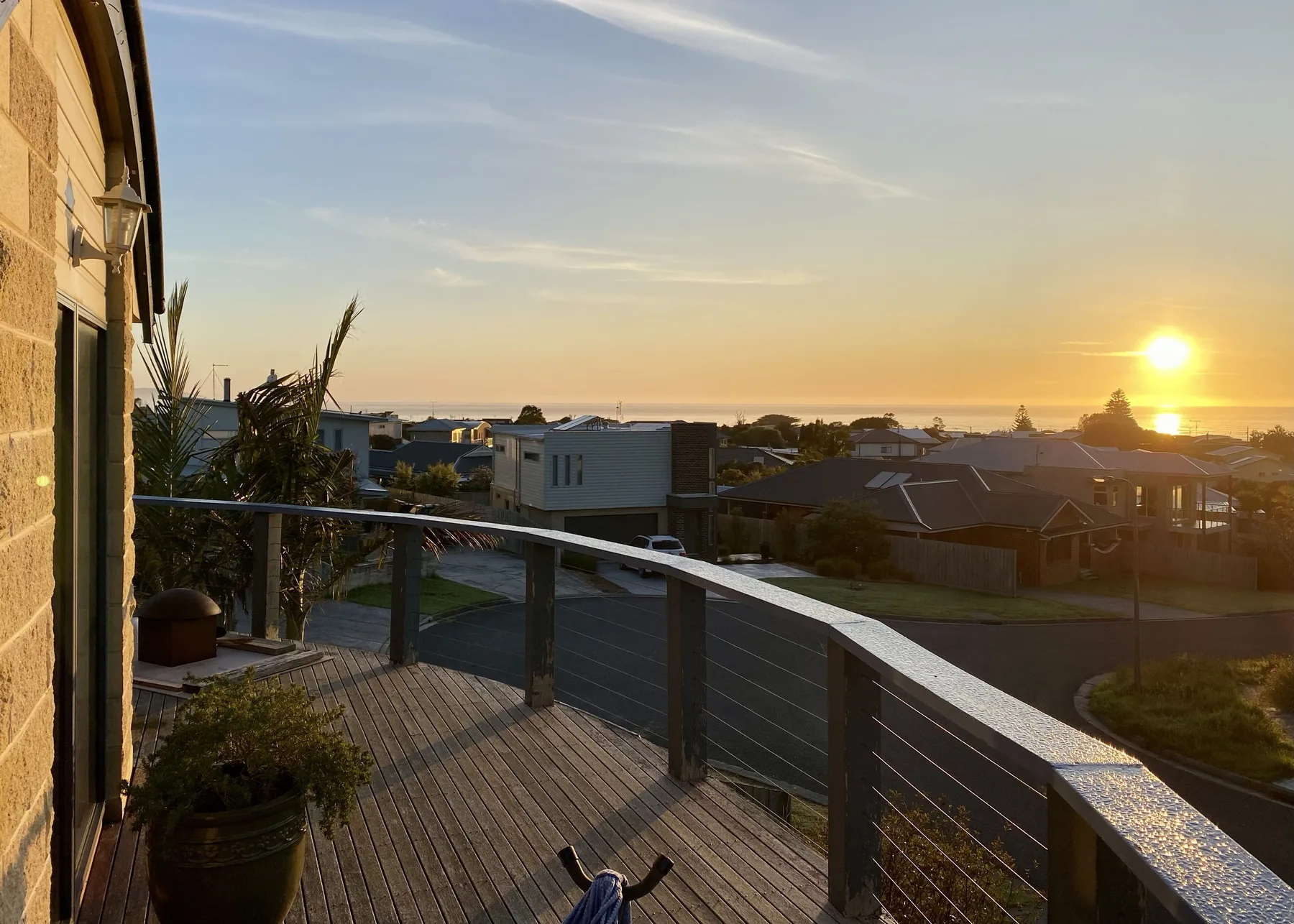 Una terraza exterior elevada ofrece vistas de casas cercanas al atardecer.