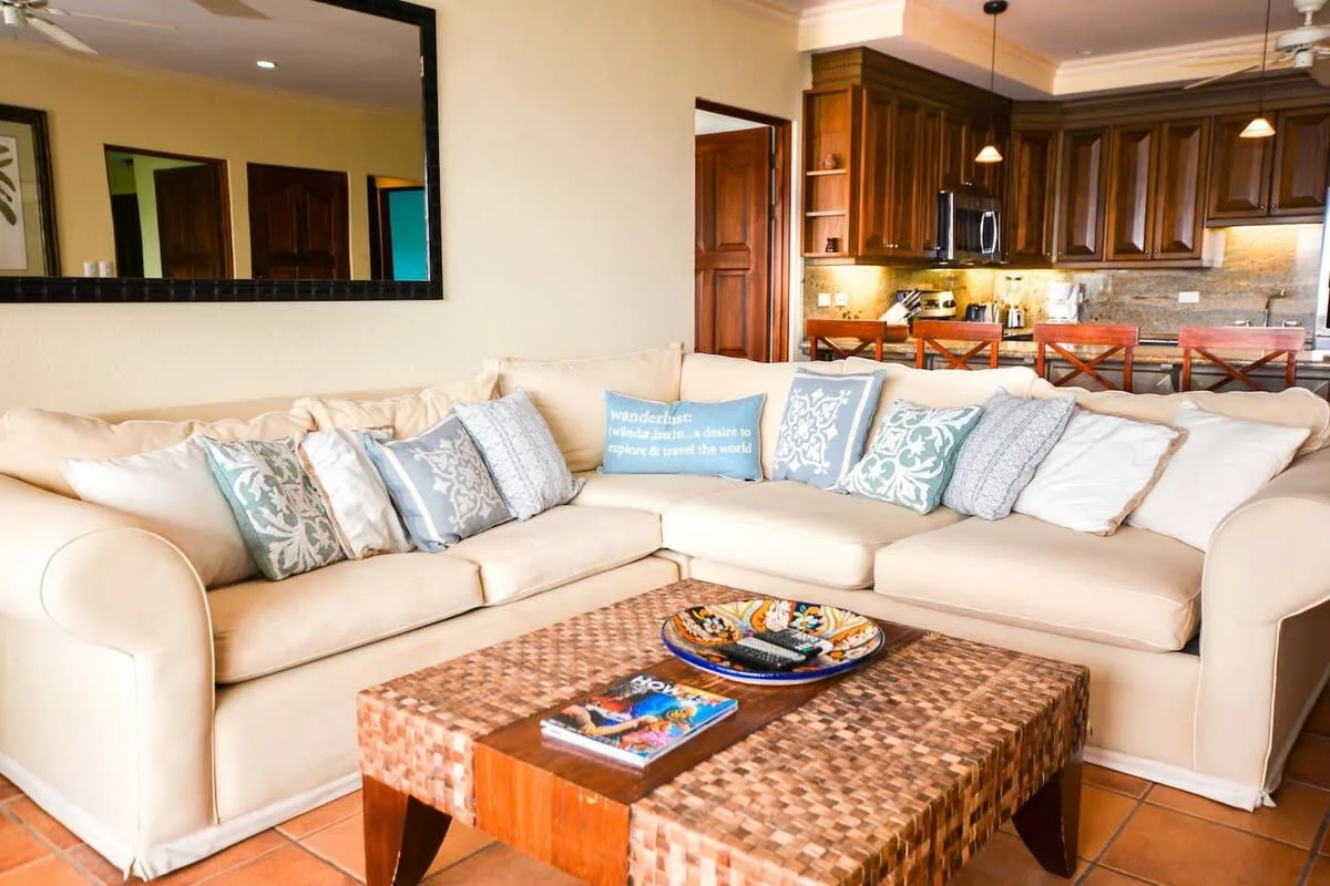 A living room with a large sectional sofa and a wooden coffee table.