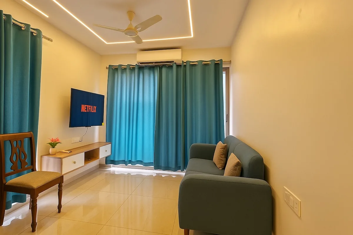 Una sala de estar con cortinas turquesa, un sofá y un televisor.