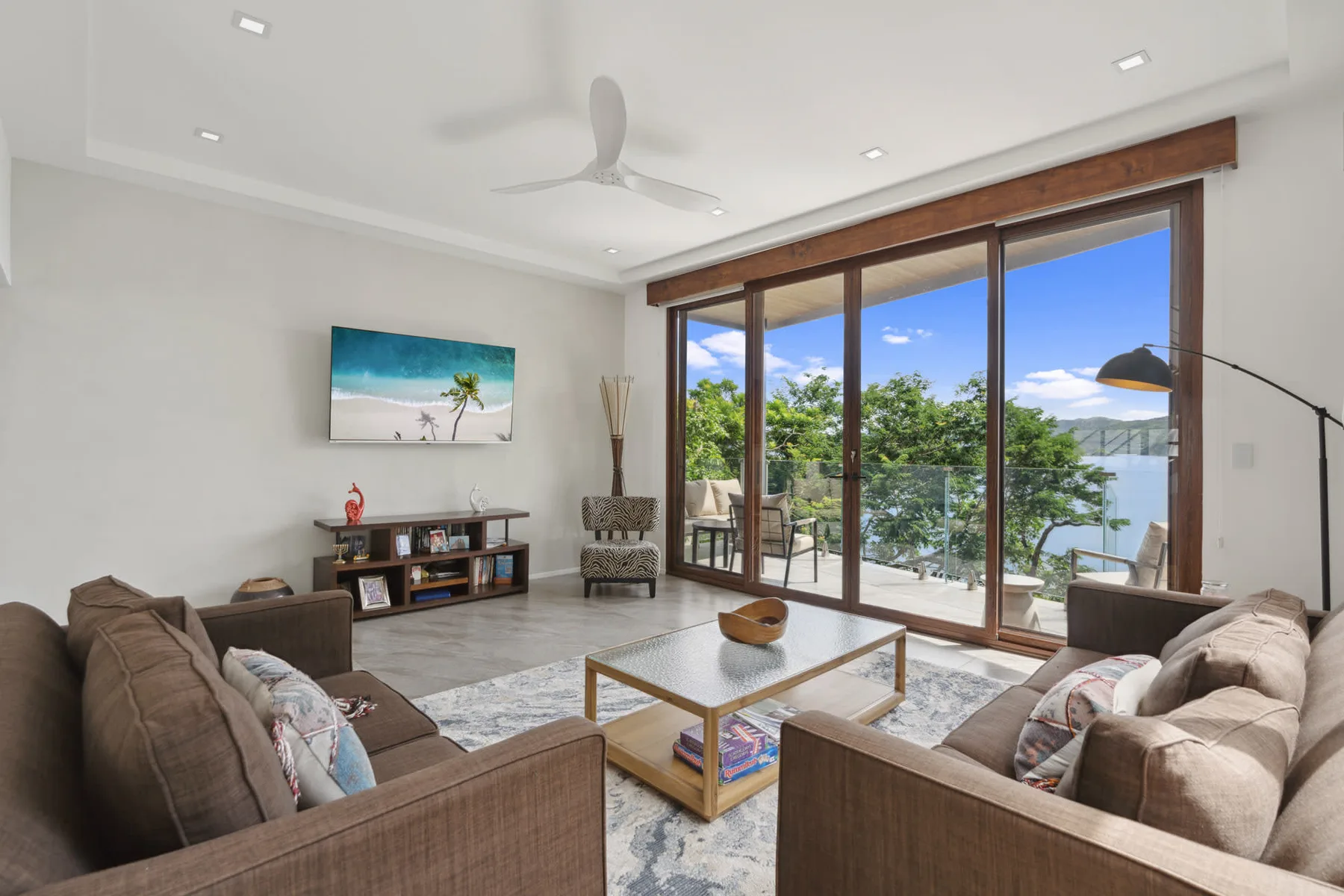 A bright living room with seating arranged around a coffee table and large glass doors.