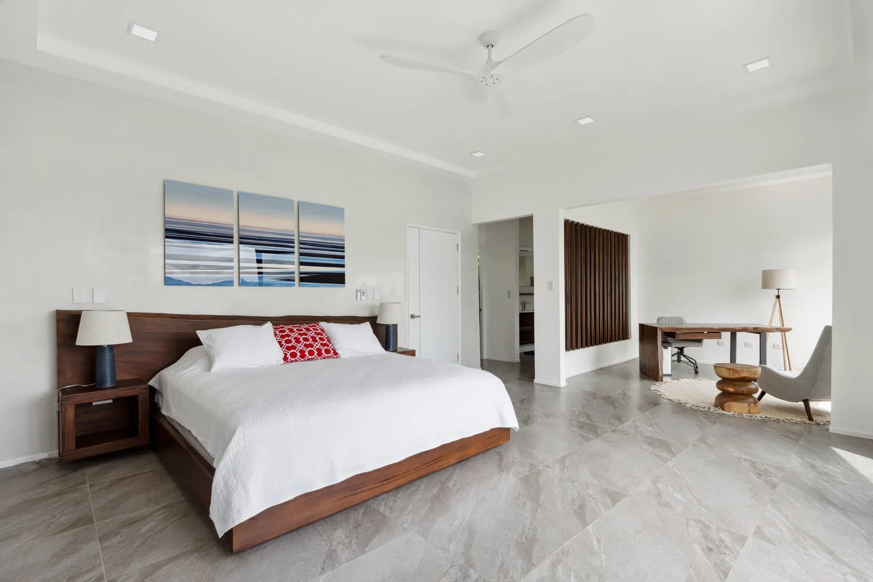 A bright bedroom with a large bed and desk.