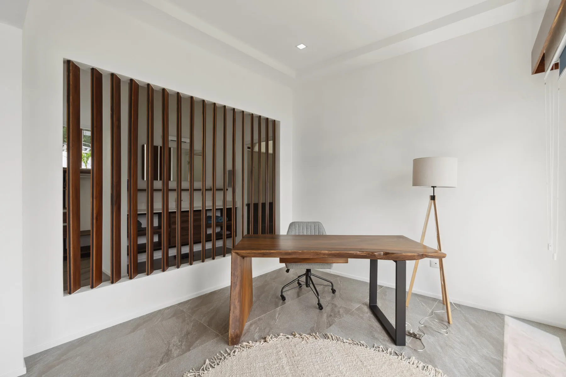 A bright workspace with a wooden desk and a floor lamp.
