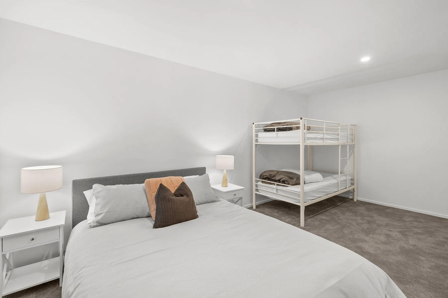 Un dormitorio con una cama doble y una litera.