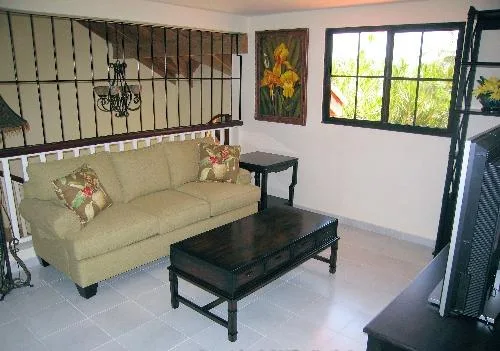 A living room with seating, a coffee table, and a window.