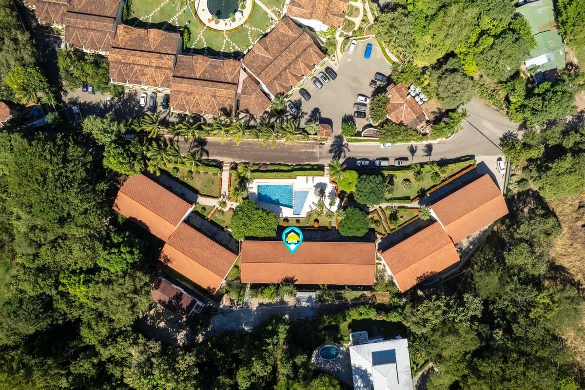 Shared amenity: Aerial view of a landscaped property with red-roofed buildings and a pool.