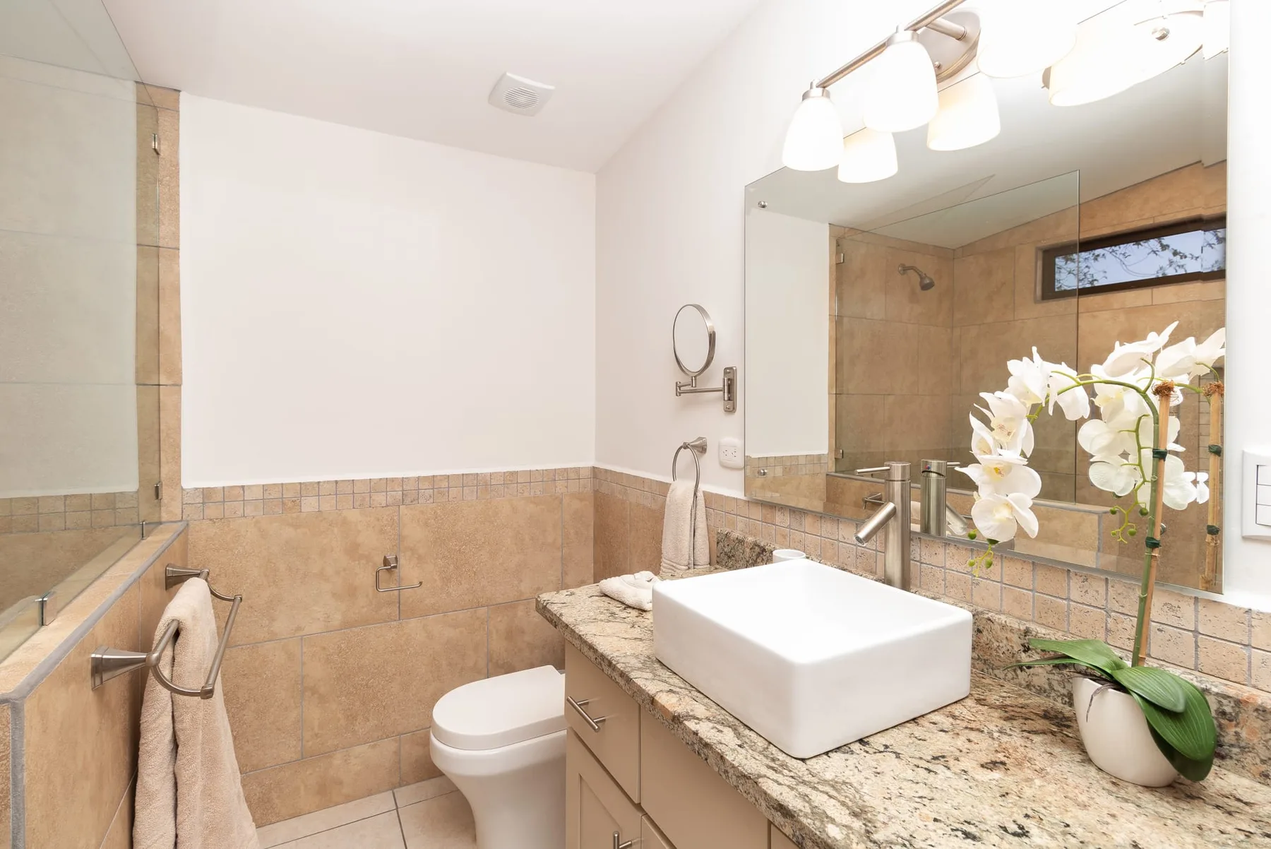 A bathroom with a sink and mirror above a stone countertop.