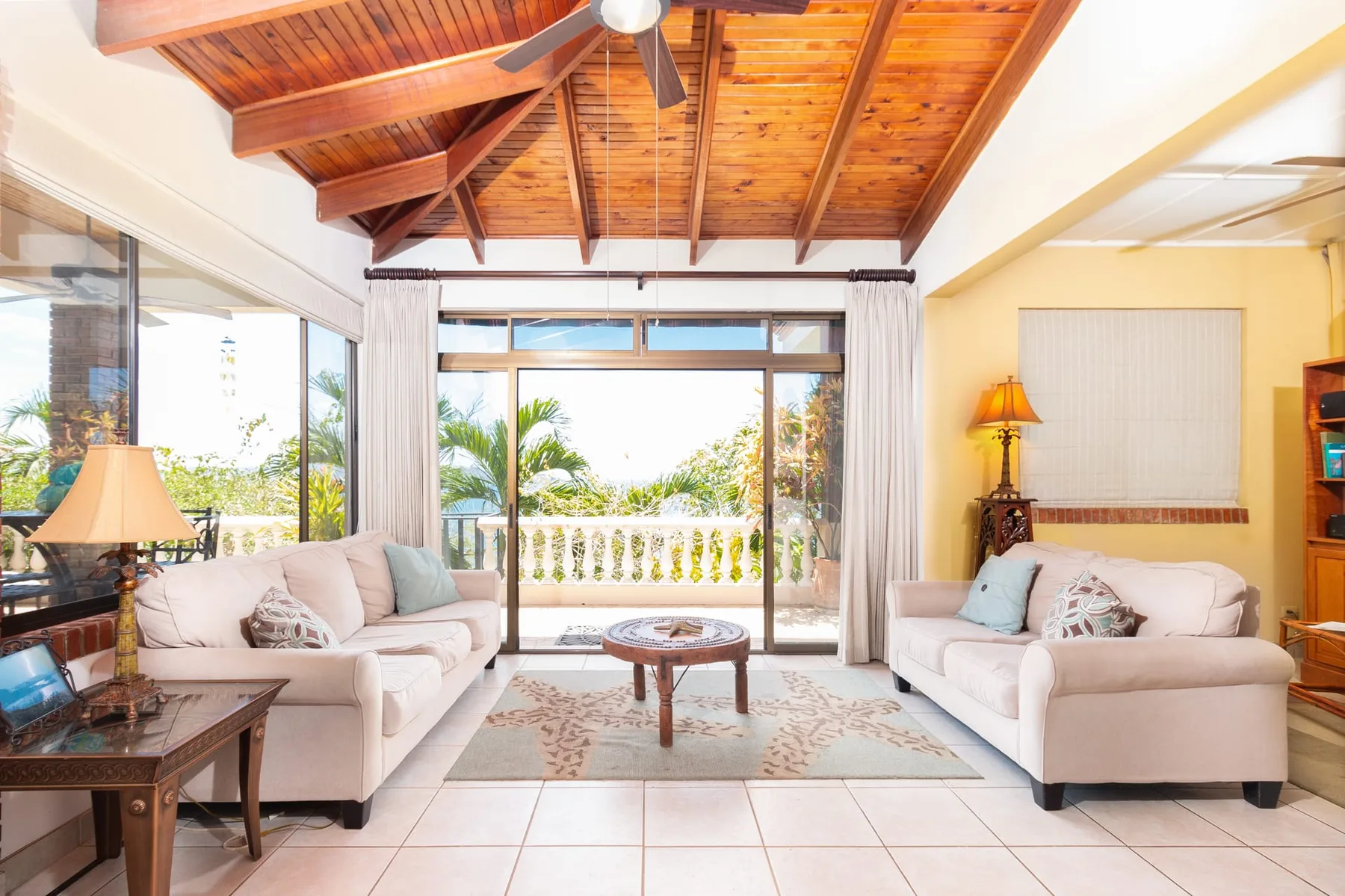 A bright living room with seating, a coffee table, and sliding glass doors.
