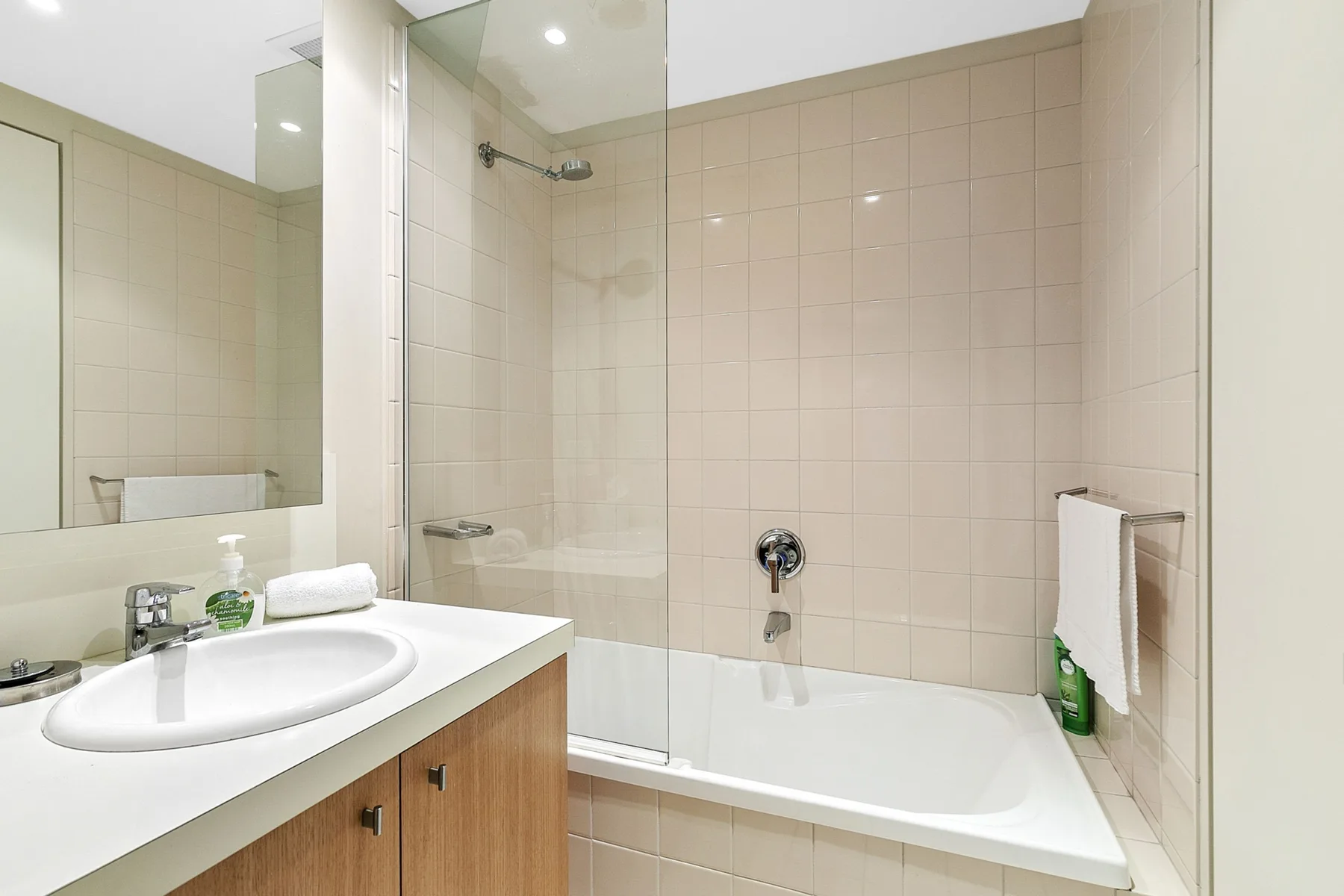 Un baño alicatado con bañera, ducha y lavabo.