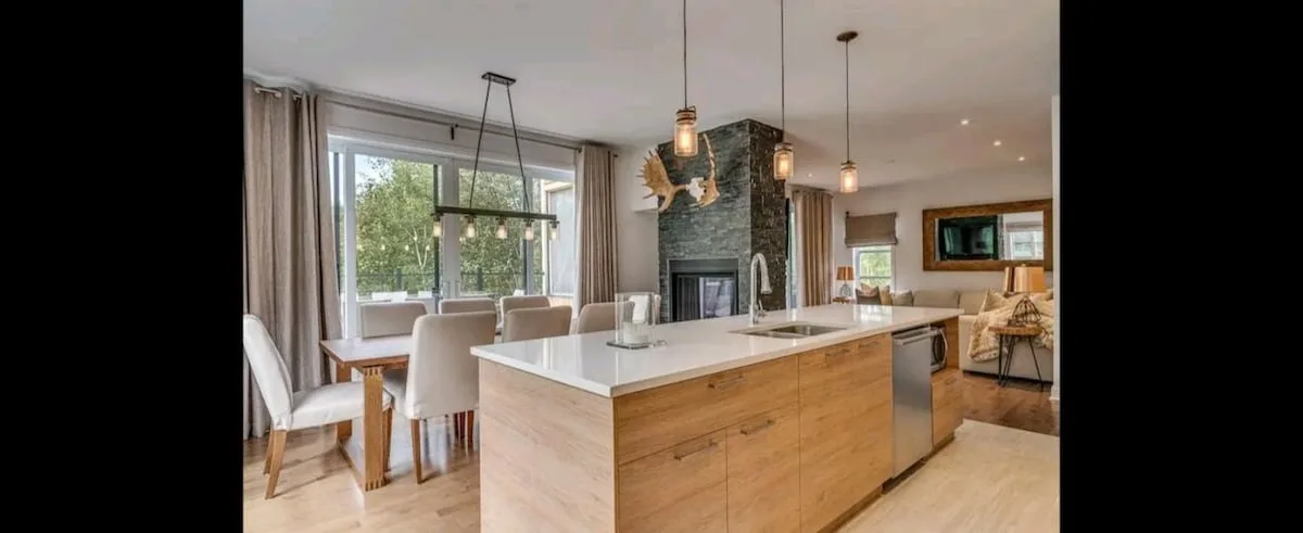 Una cocina y comedor abiertos con una isla grande y una mesa de comedor.