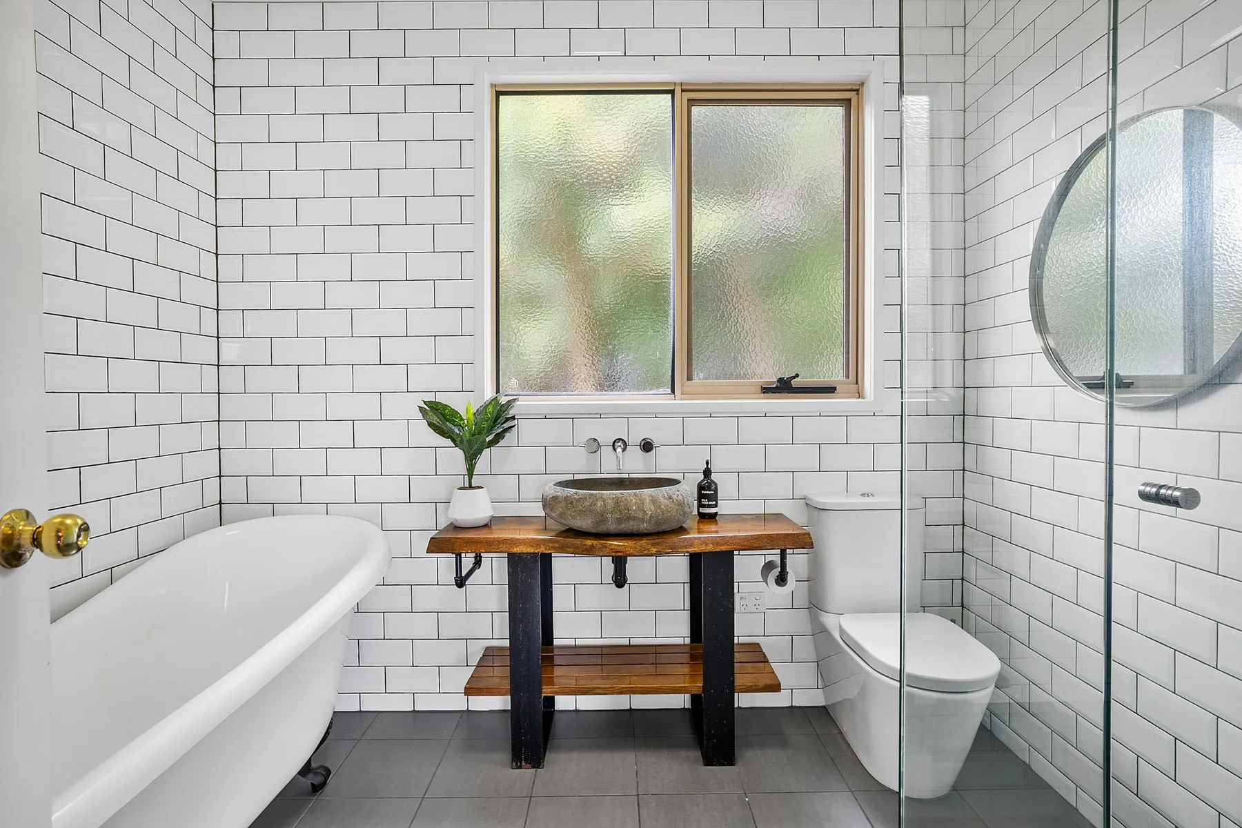 Un baño alicatado con bañera, lavabo e inodoro.