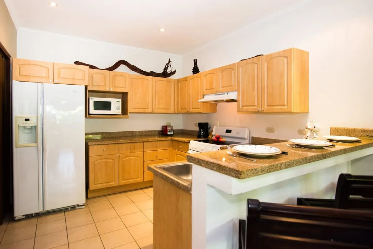 A kitchen with wooden cabinets and a central counter.