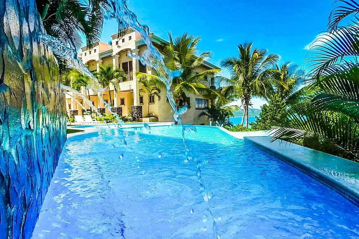 Shared amenity: A swimming pool sits beside a building among palm trees.