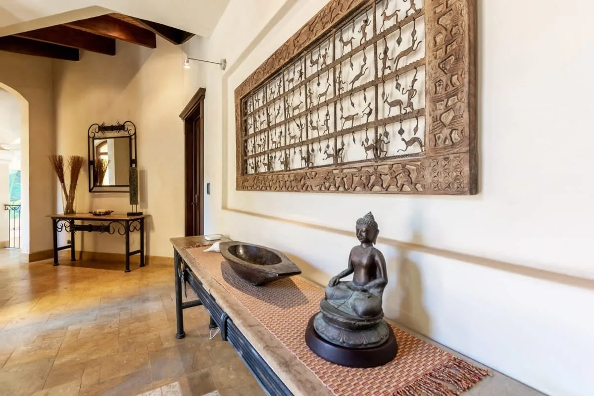An interior hallway with a long console table and framed decorative artwork.