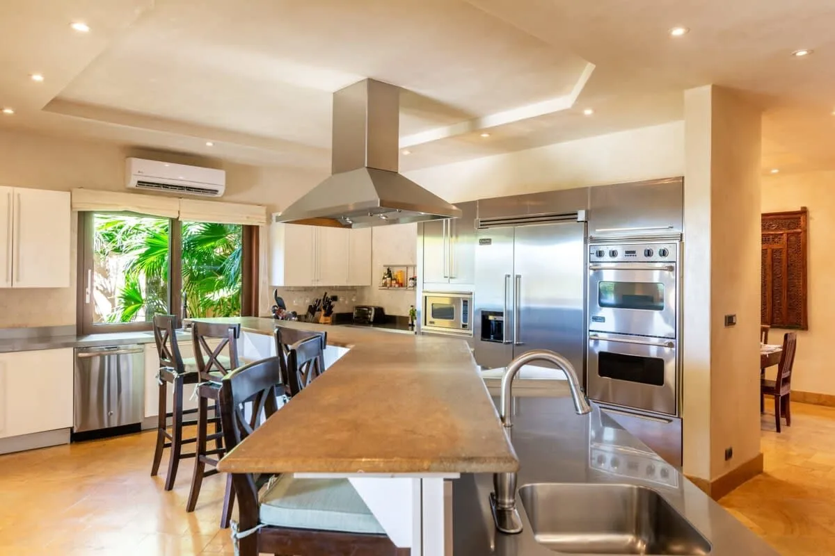A spacious kitchen with a long island, stainless steel appliances, and a dining area.