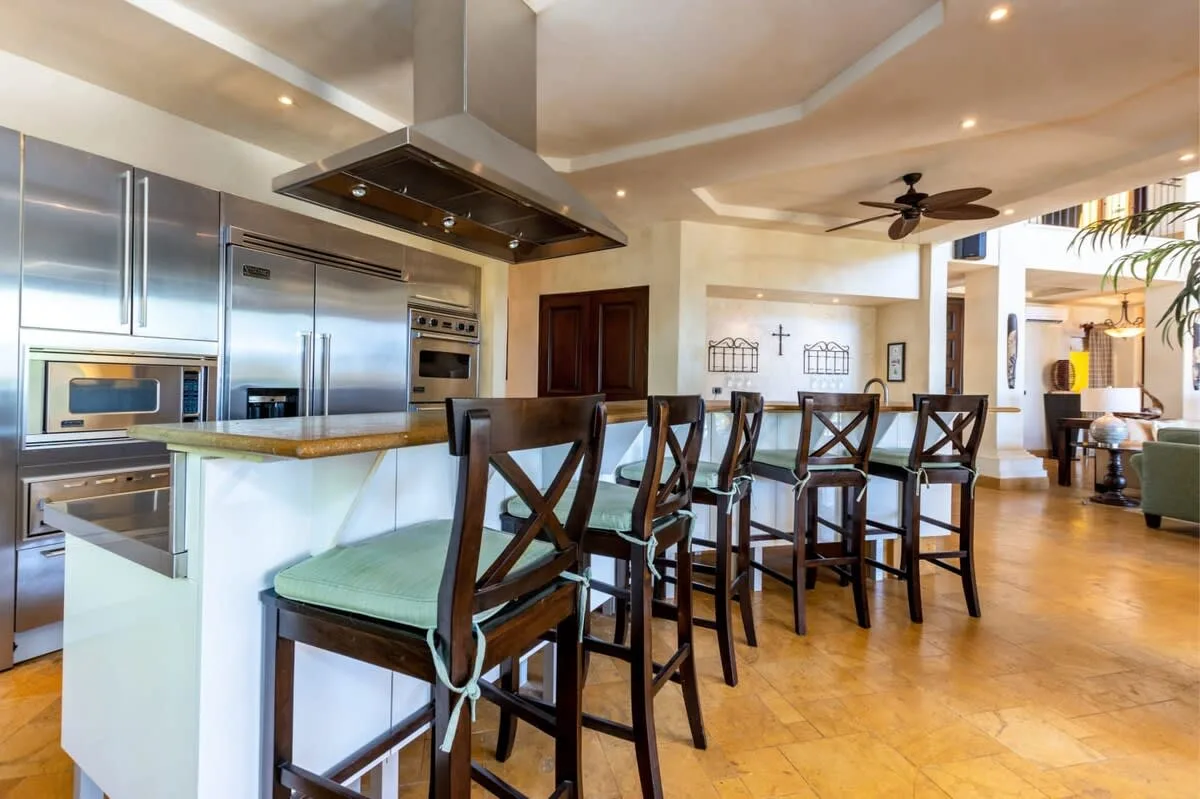 An open kitchen and dining area with a long counter and bar seating.