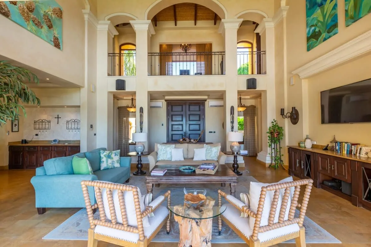A spacious living room with seating arranged around a glass coffee table.