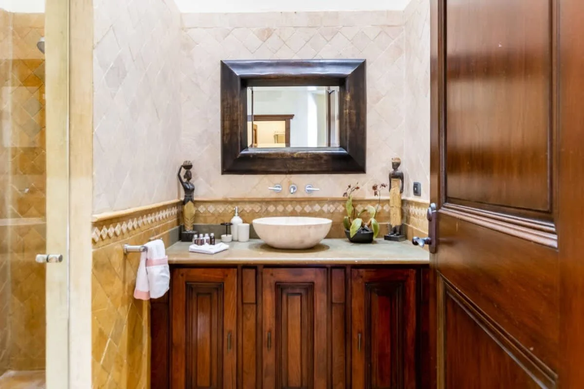 A bathroom vanity with a sink, mirror, and wooden cabinetry.