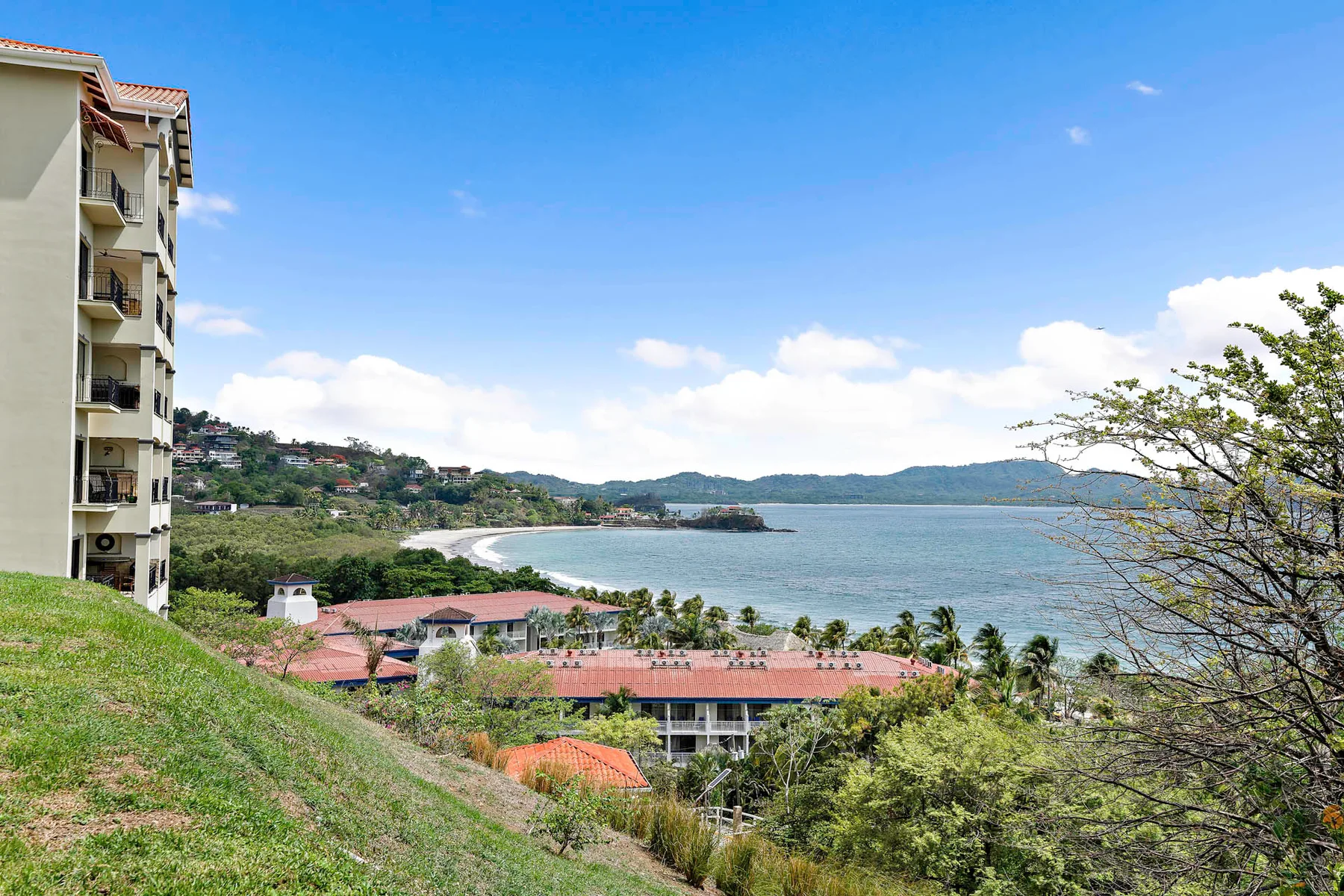 Shared amenity: A coastal landscape overlooks a curved shoreline, blue water, and hillside buildings.