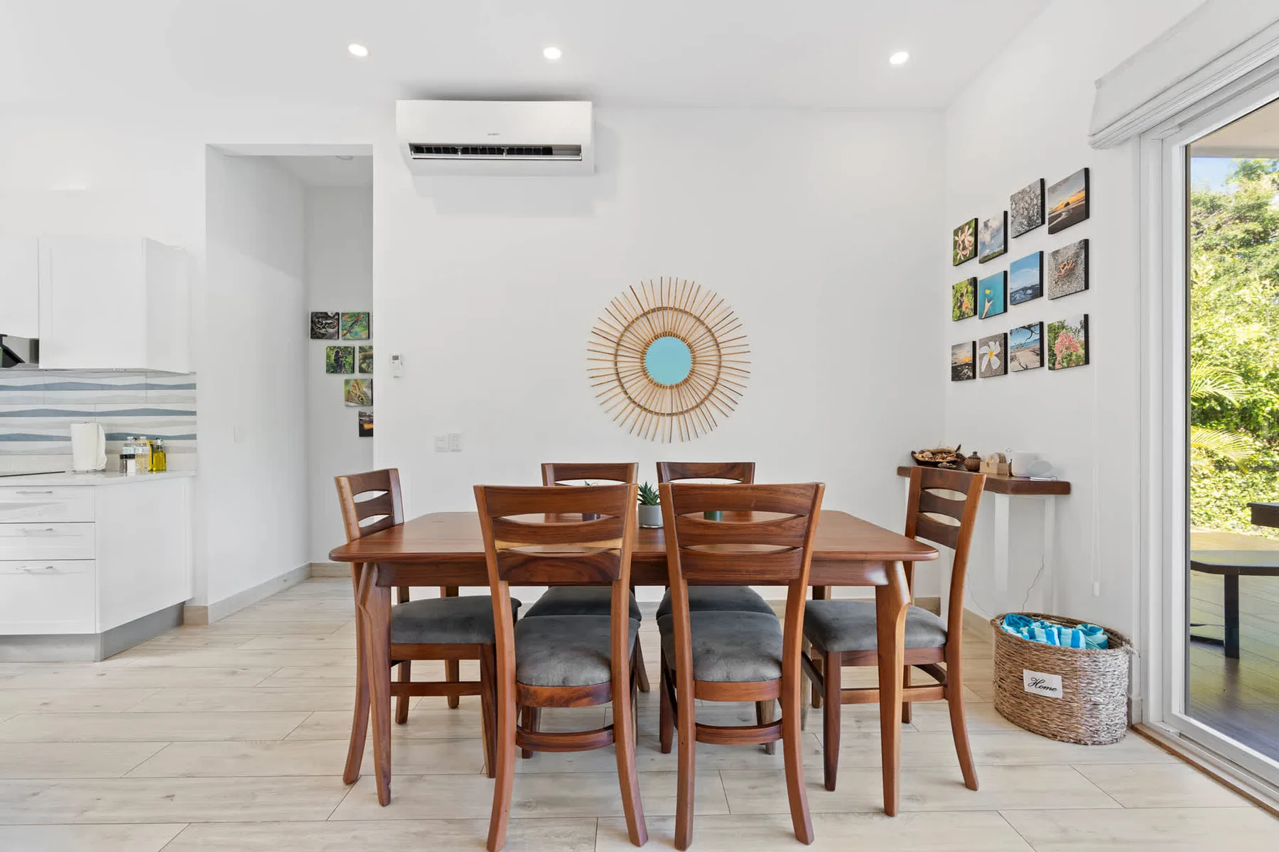 A bright dining area with a wooden table and chairs beside the kitchen.
