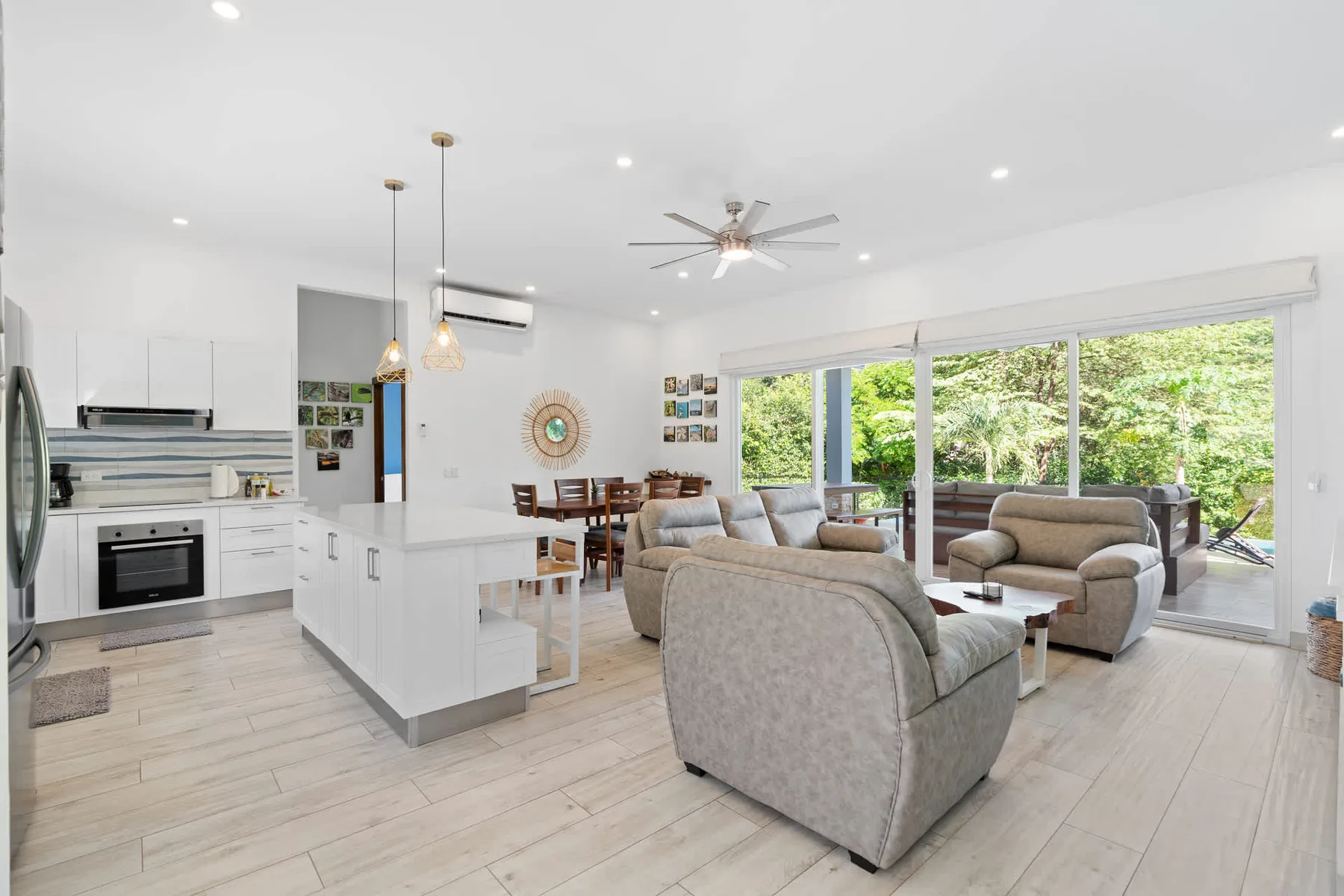 An open-plan kitchen and living area with seating beside large glass doors.