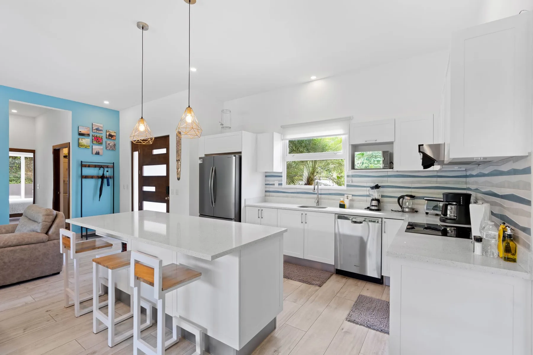A bright open-plan kitchen with a large island and adjoining living area.