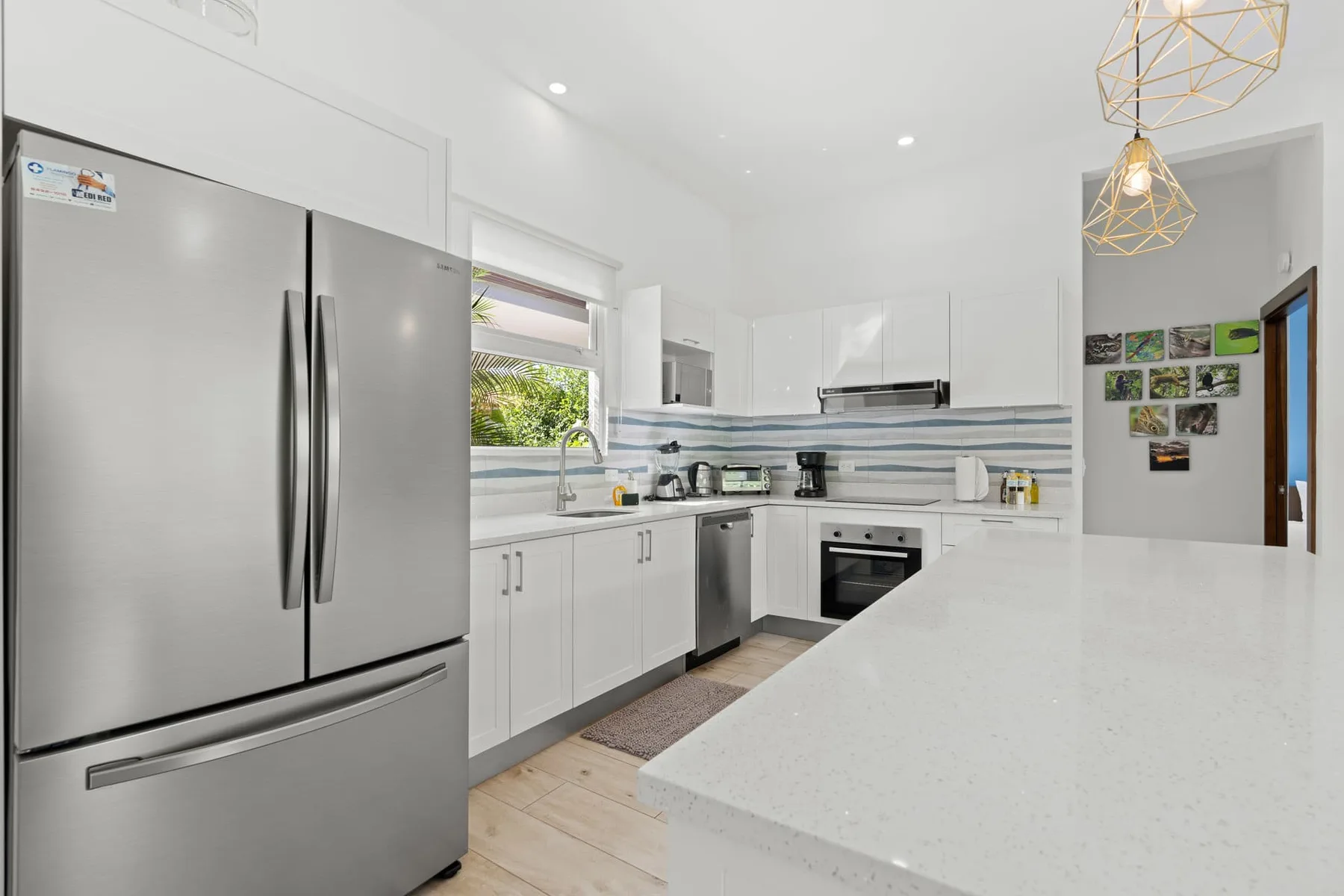 A bright modern kitchen with white cabinets and a large island.