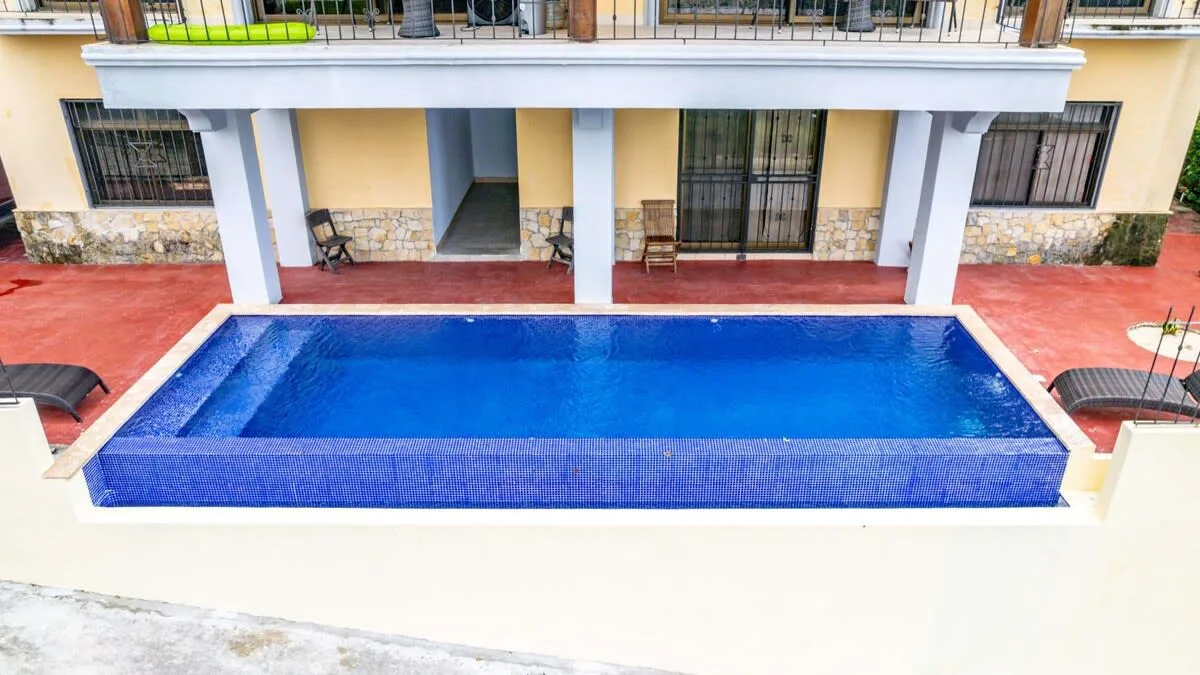 Shared amenity: A swimming pool sits in front of a building with a covered patio.