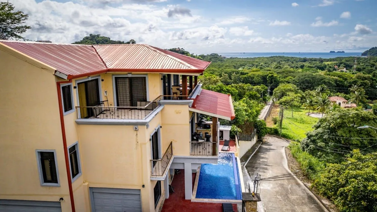 Shared amenity: A multi-story building with balconies and a blue pool overlooks green countryside.