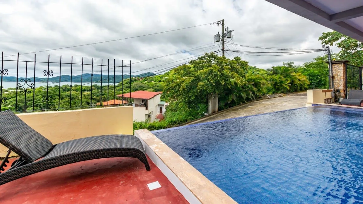 Shared amenity: An outdoor swimming pool beside a terrace with lounge seating.