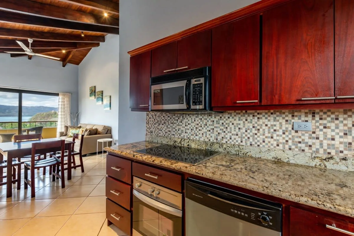 A kitchen with dark wood cabinets and an adjoining dining area.