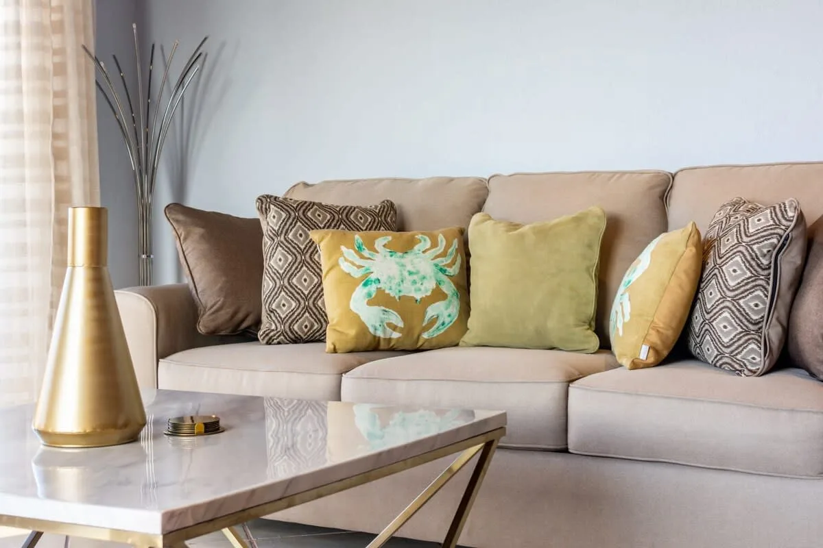 Living room with a beige sofa and a marble coffee table.