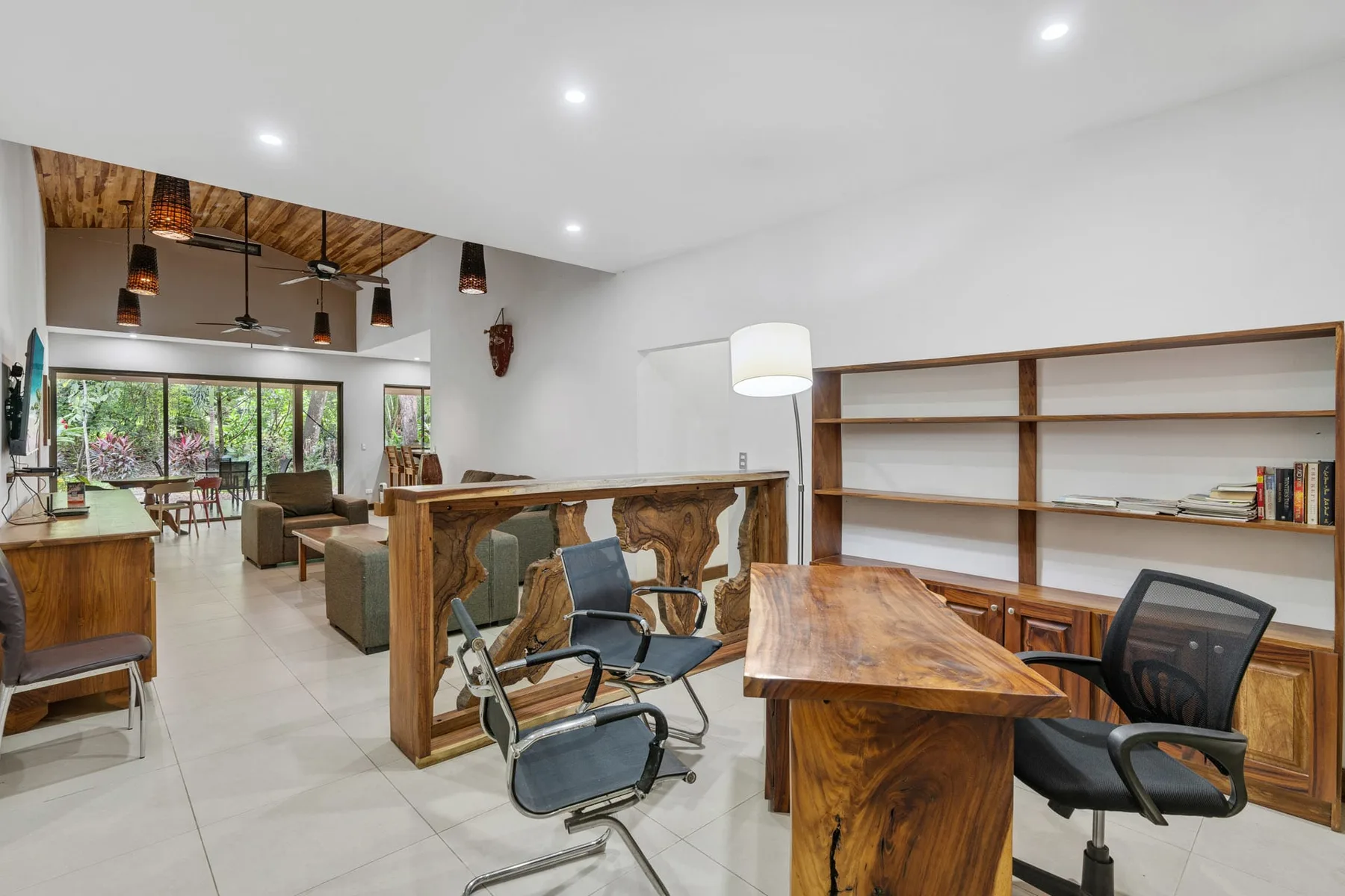 A bright open room with wooden tables, seating, and built-in shelving.