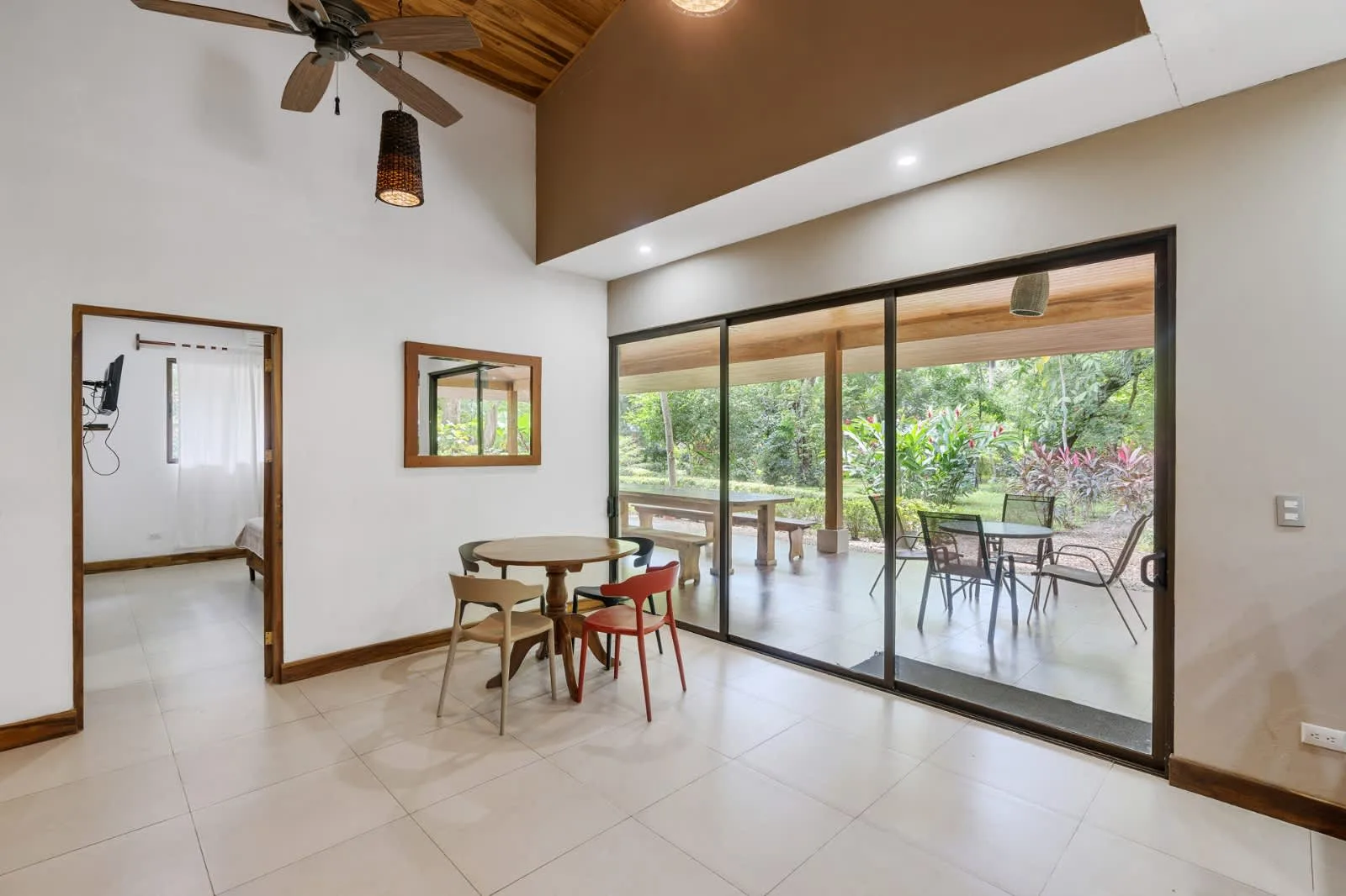 A bright dining area opens through sliding glass doors to a covered patio and garden.