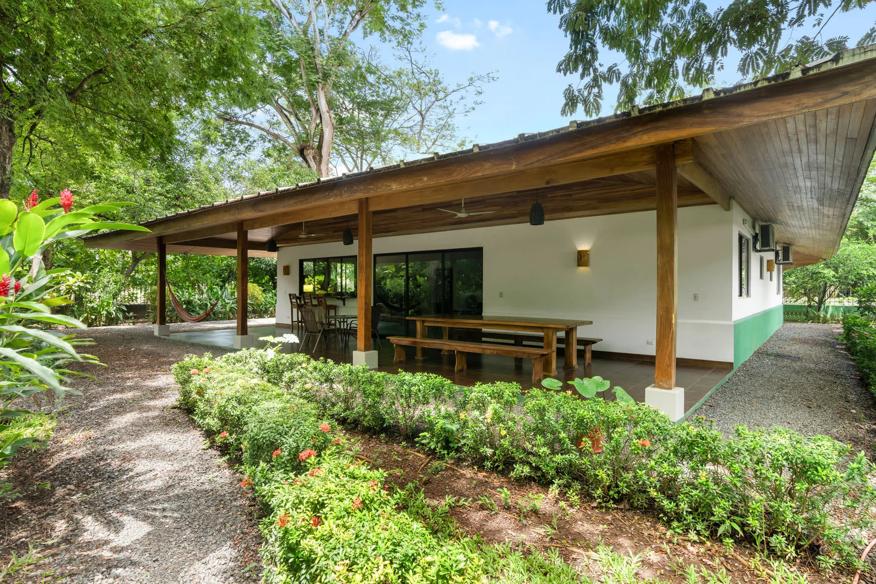 A single-story building with a covered outdoor seating area and garden.