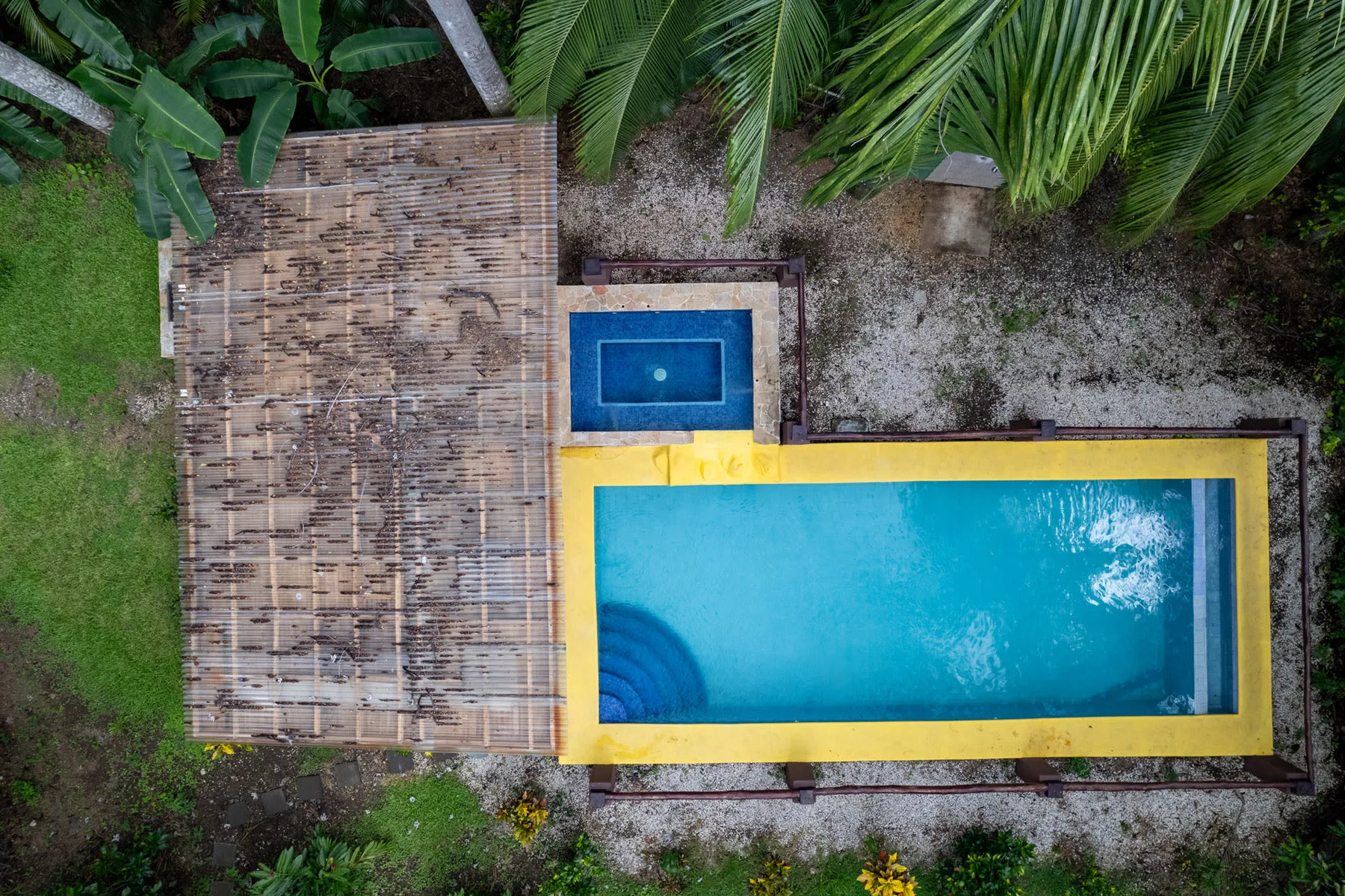 Shared amenity: Aerial view of a swimming pool beside a shaded deck.