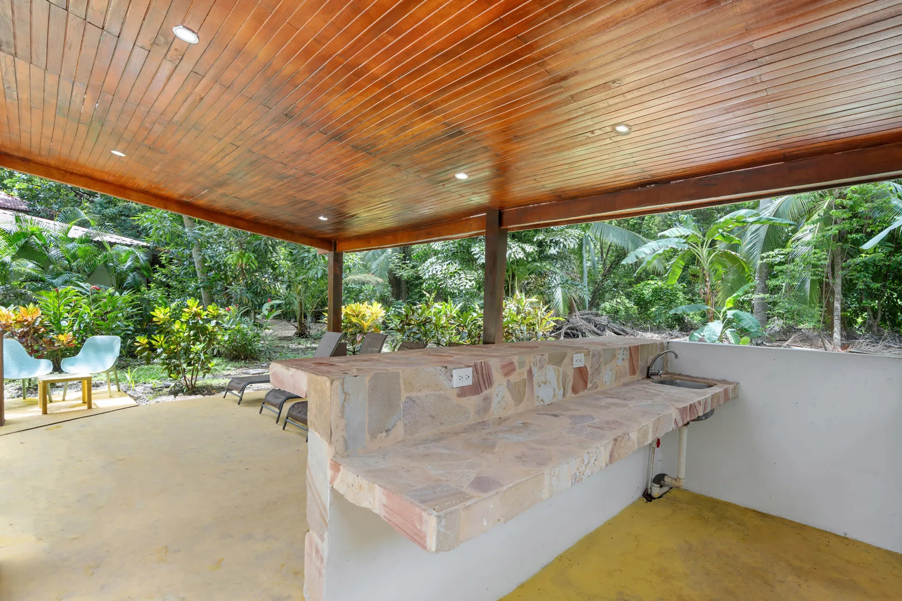 Shared amenity: A covered outdoor counter area overlooks lush tropical greenery.