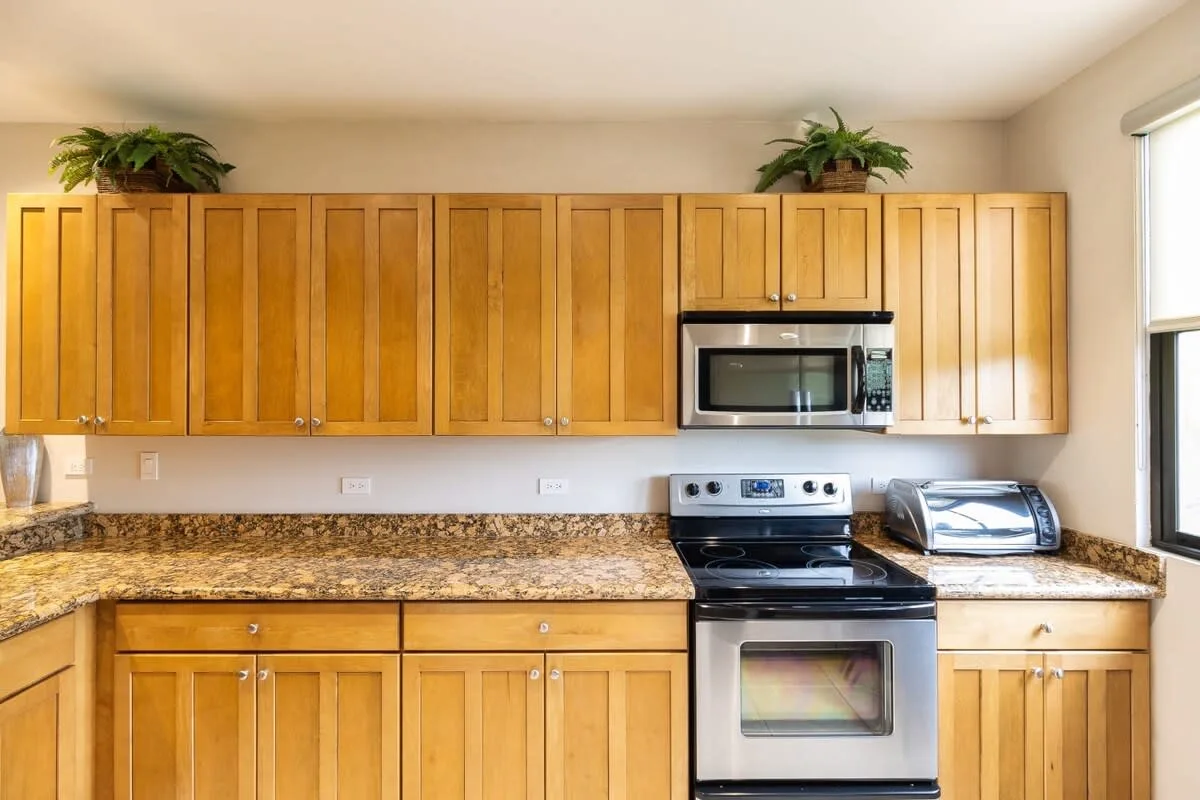 Una cocina con gabinetes de madera, una encimera y electrodomésticos de acero inoxidable.