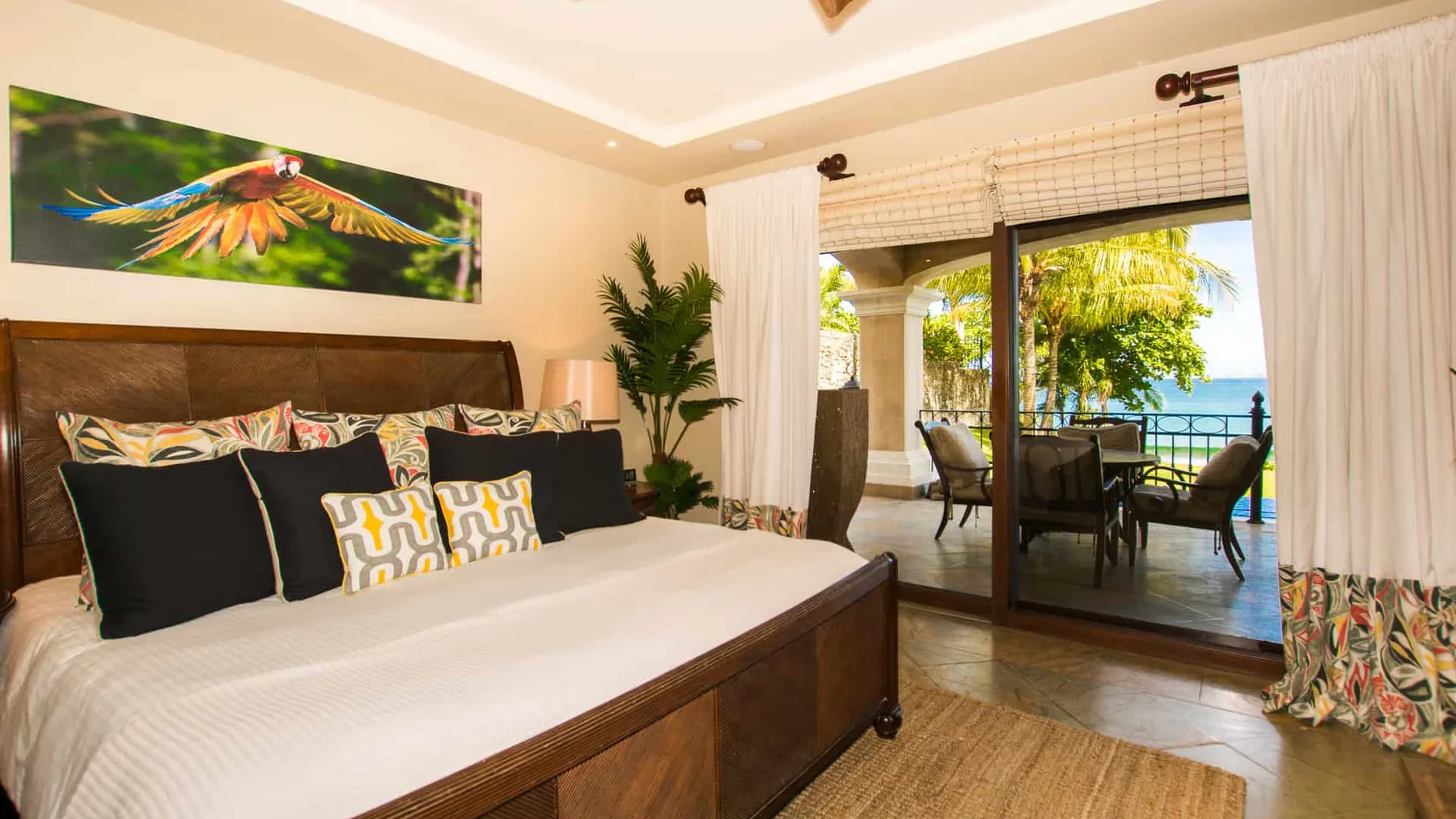 A bedroom with a large bed beside sliding glass doors opening onto a patio.