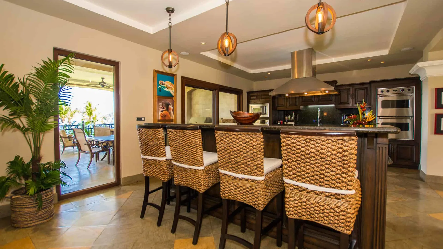 A kitchen with a long island and woven bar seating.