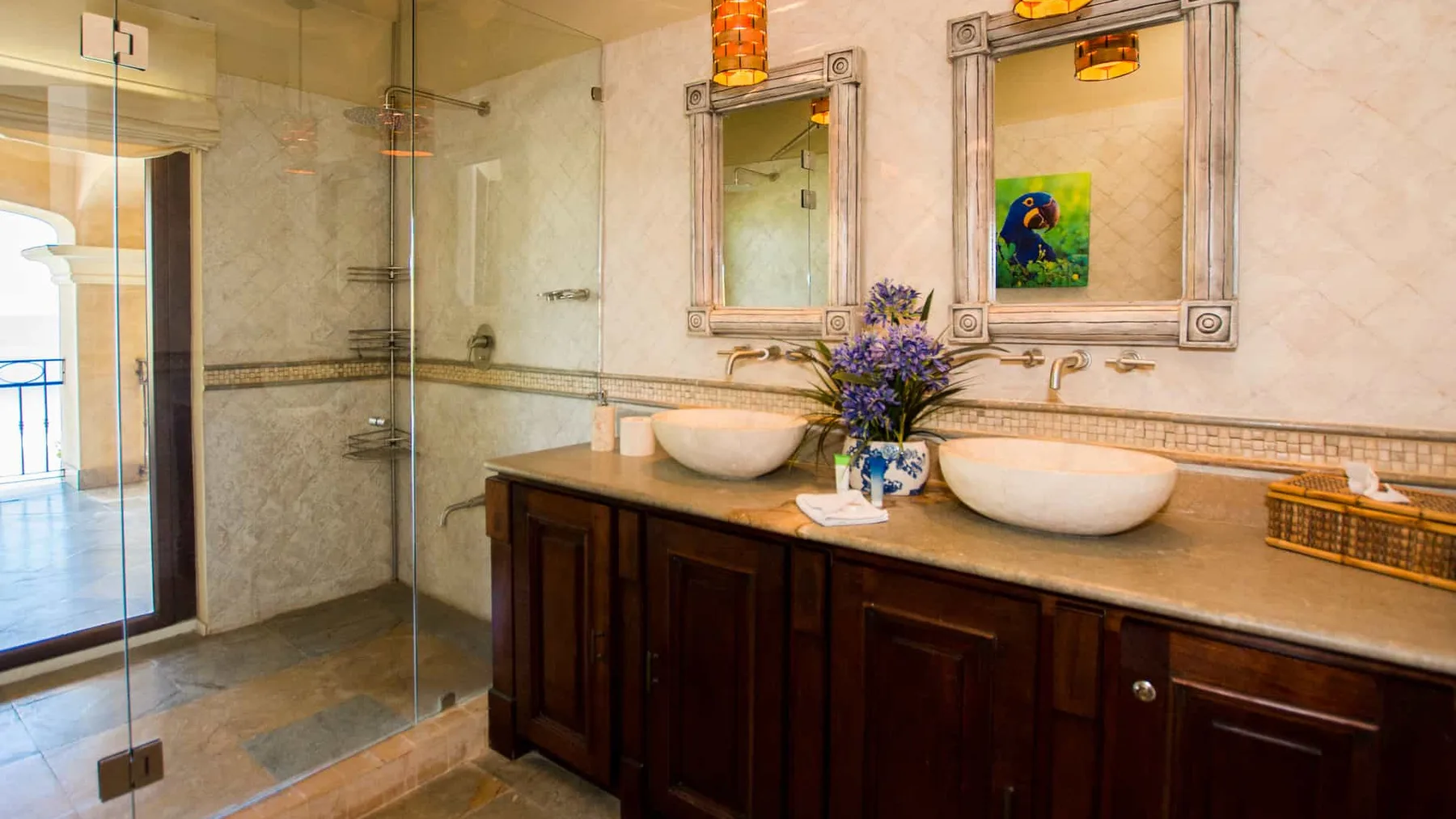 A bathroom with a glass shower and a double-sink vanity.