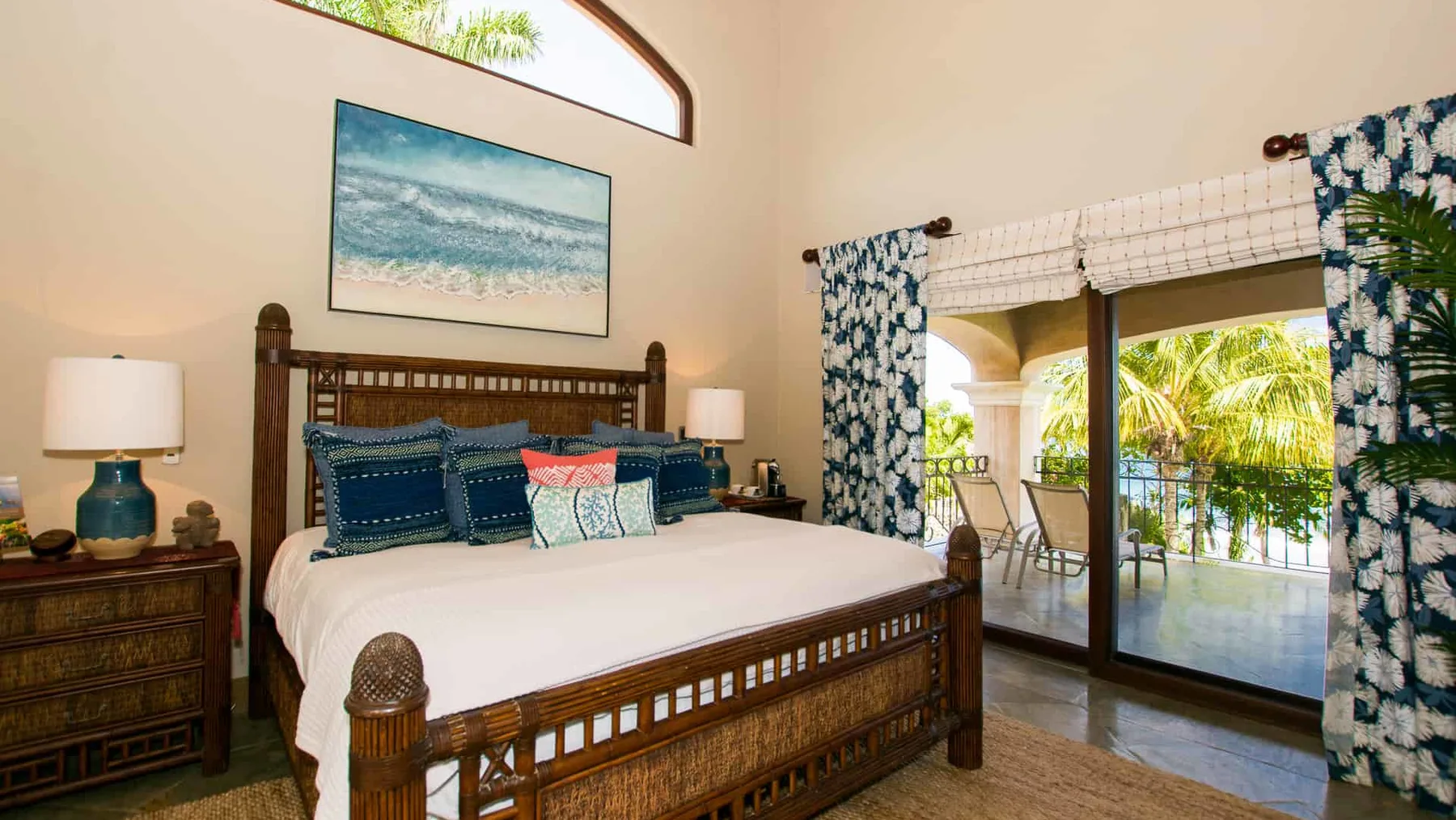 A bedroom with a large bed and sliding glass doors opening onto a balcony.