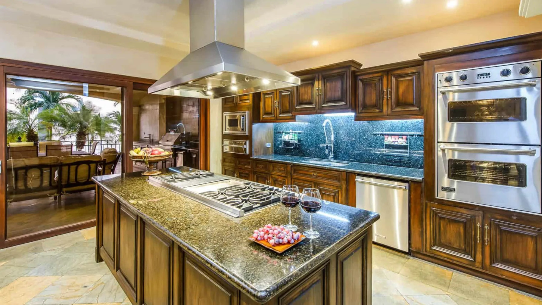 A spacious kitchen features dark wood cabinets, stone counters, and a central island.