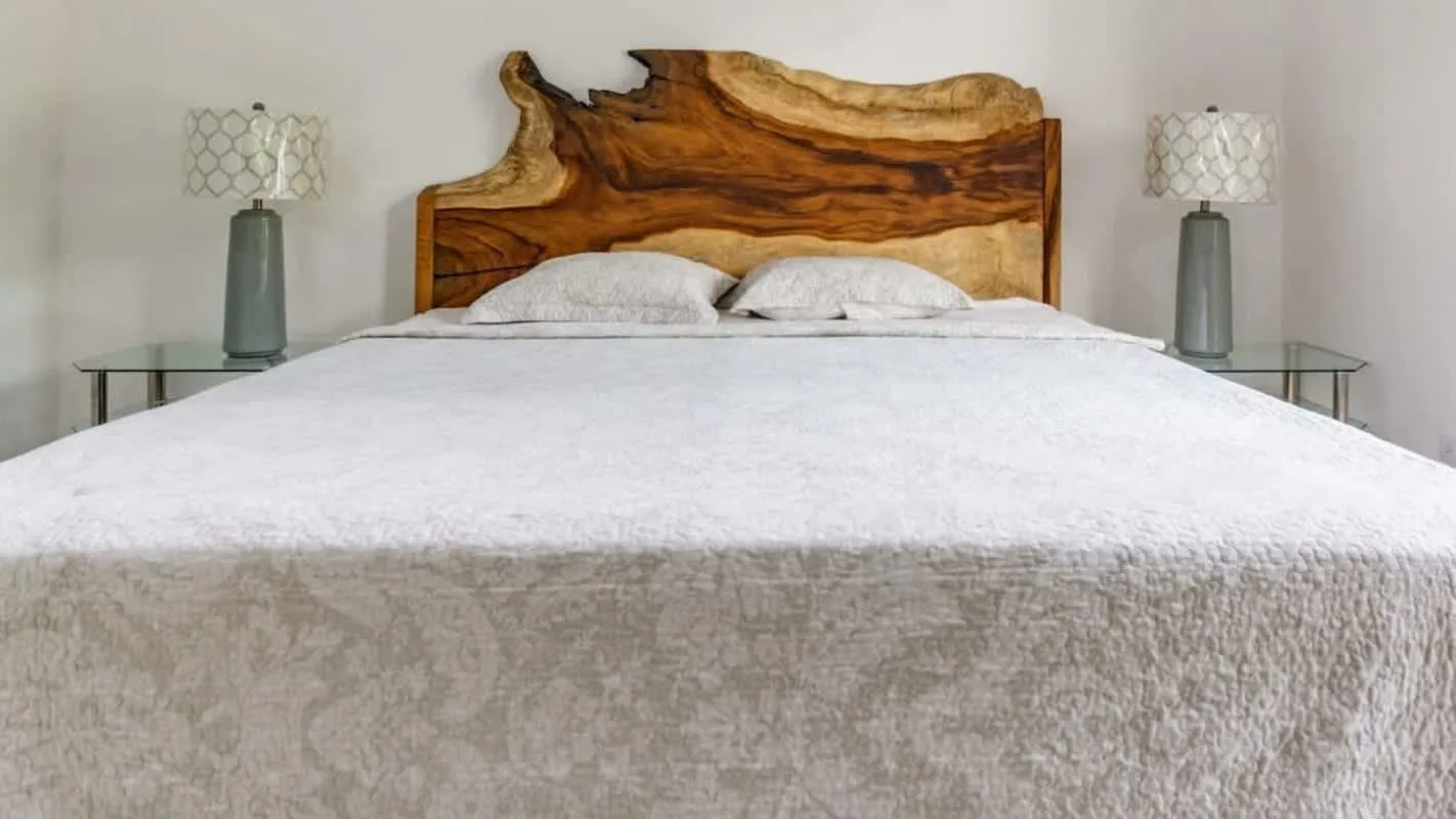 A bedroom with a bed and a distinctive wooden headboard.