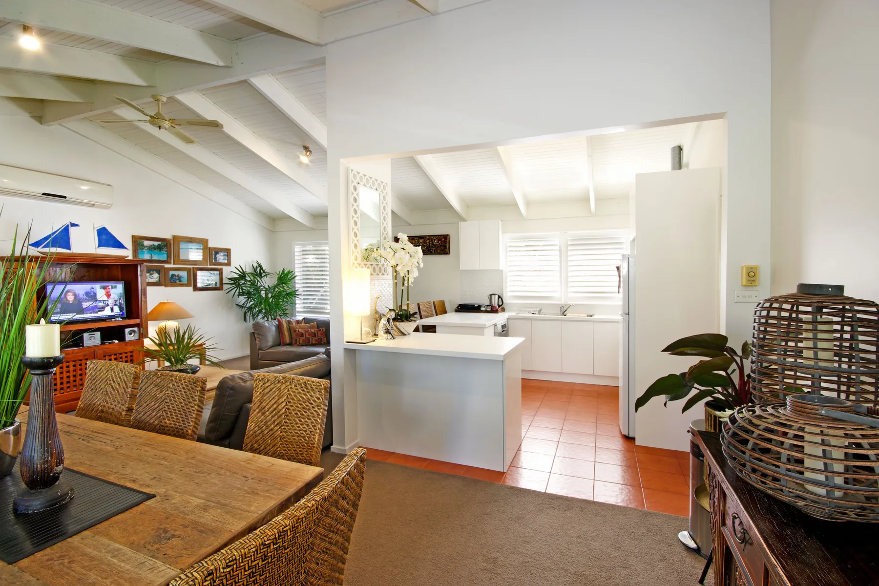 An open dining and kitchen area with woven seating and a bright countertop.