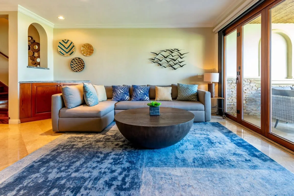 A living room with seating, a round coffee table, and large glass doors.