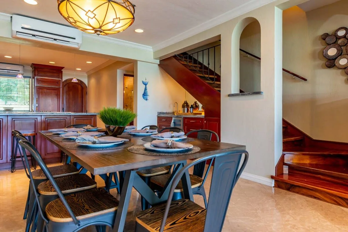 A dining area with a set table beside a staircase.